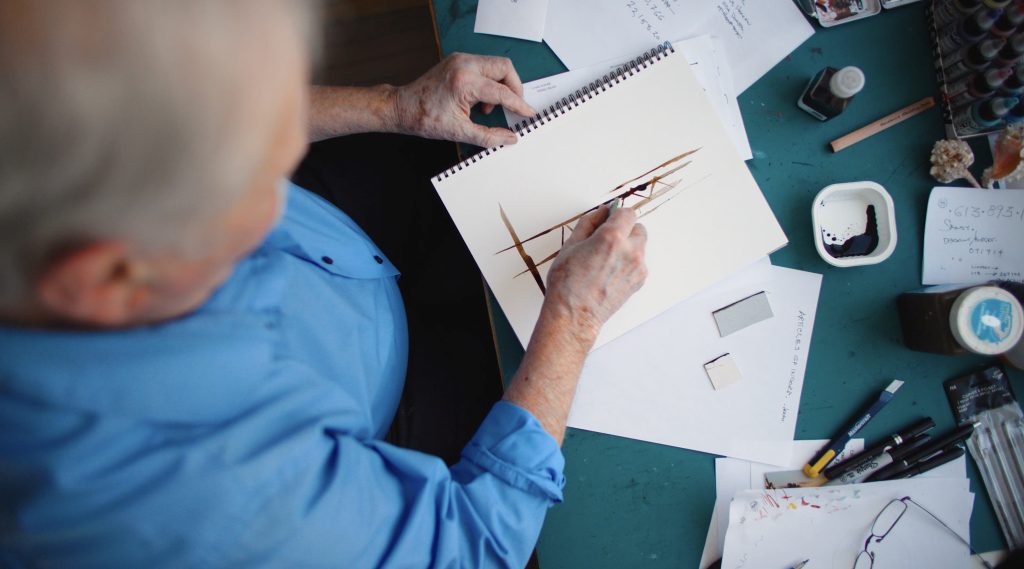 A man drawing in a sketchbook. 